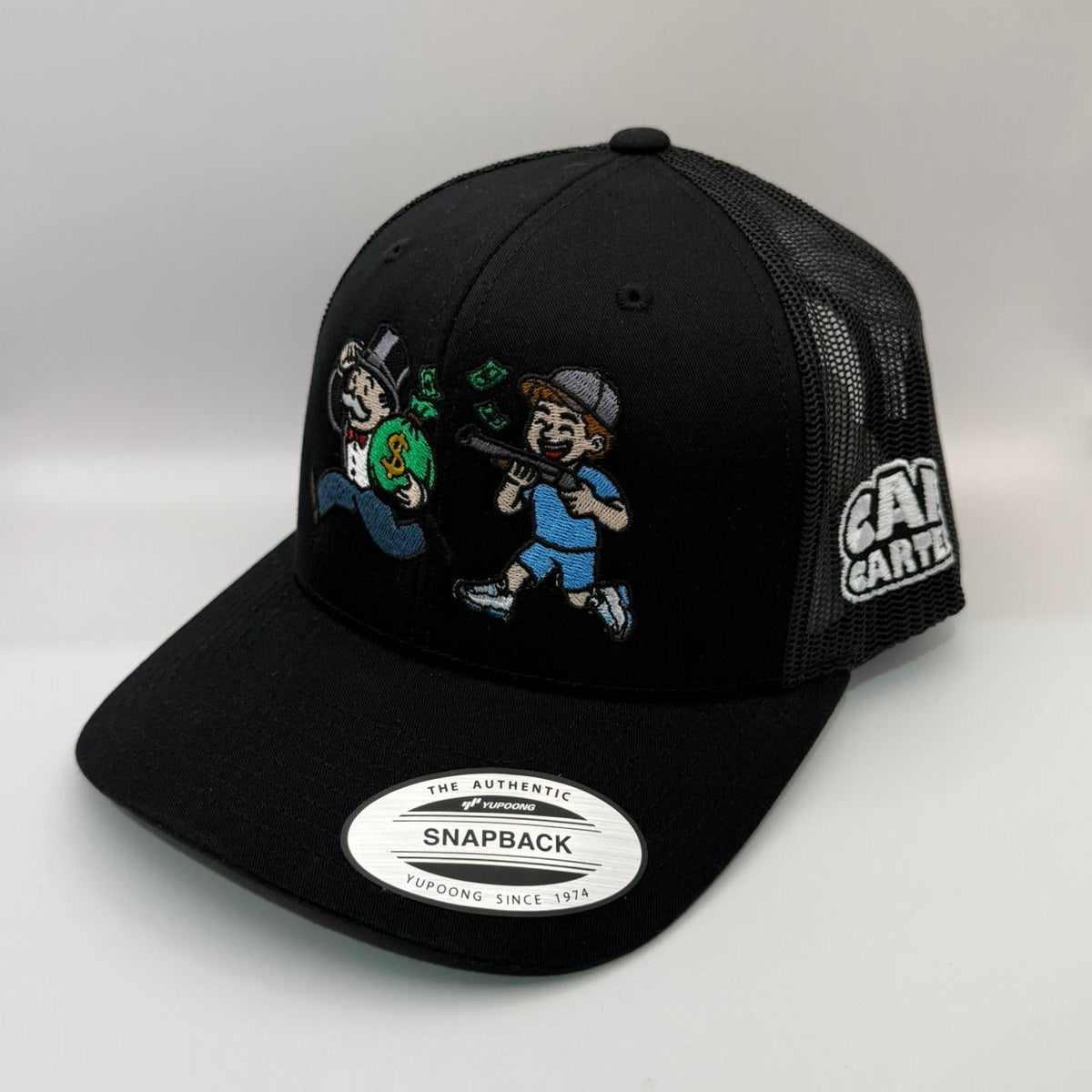 Black snapback cap with cartoon characters and 'Cartel' branding on a white background