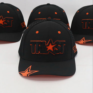 Four black baseball caps with orange logos on a white background