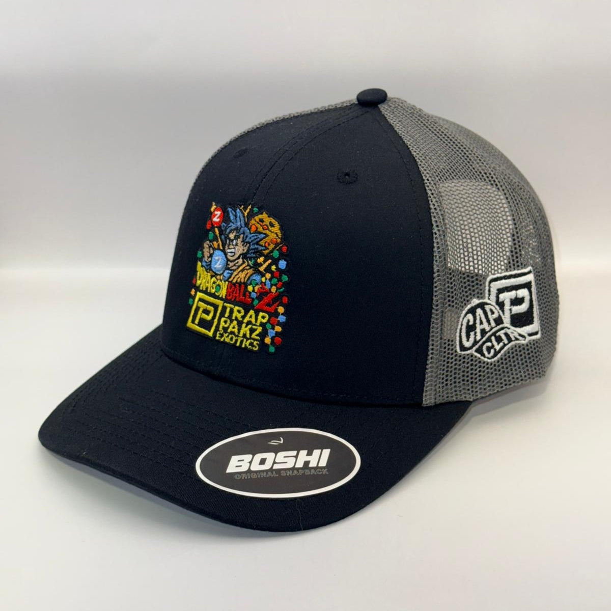 Black and gray cap with colorful graphics and brand logos on a white background