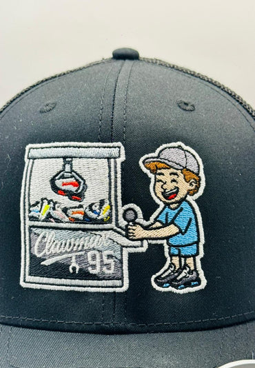 Gray cap with embroidered design of a boy playing claw machine and 'Clawmin' 95' text.