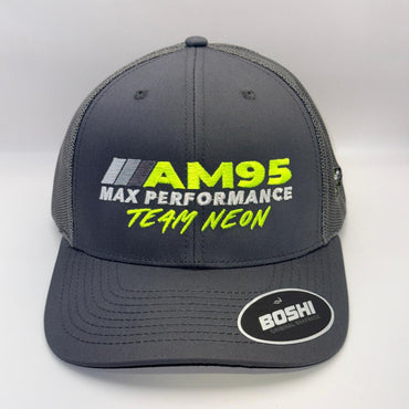 A dark gray trucker-style cap with mesh back panels, featuring 'AM95 MAX PERFORMANCE TEAM NEON' embroidered on the front in yellow and white, and a 'BOSHI' sticker on the brim.
