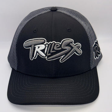 A black and gray trucker hat with a black front panel, gray mesh back, and a large stylized 'TRILEX' logo embroidered on the front.