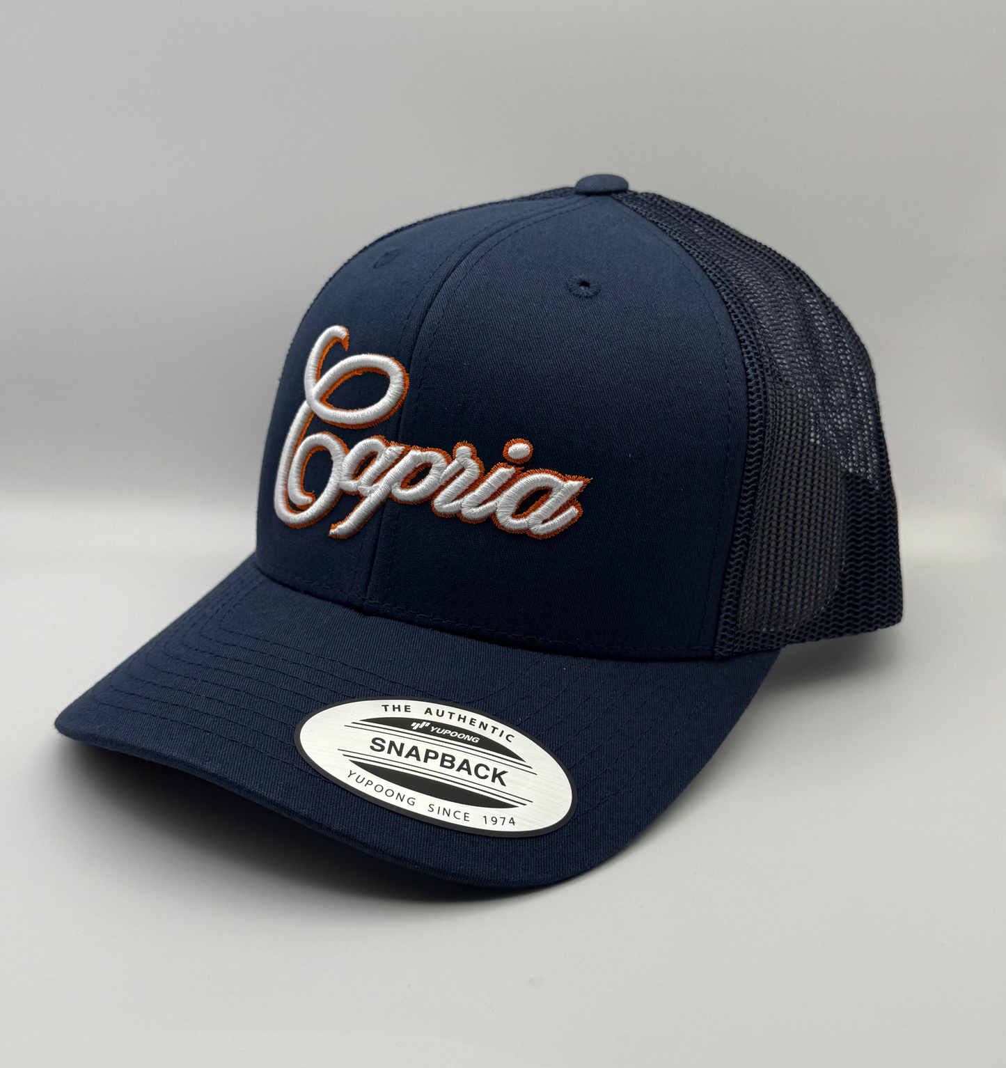 Navy blue cap with 'Capria' branding on a light gray background