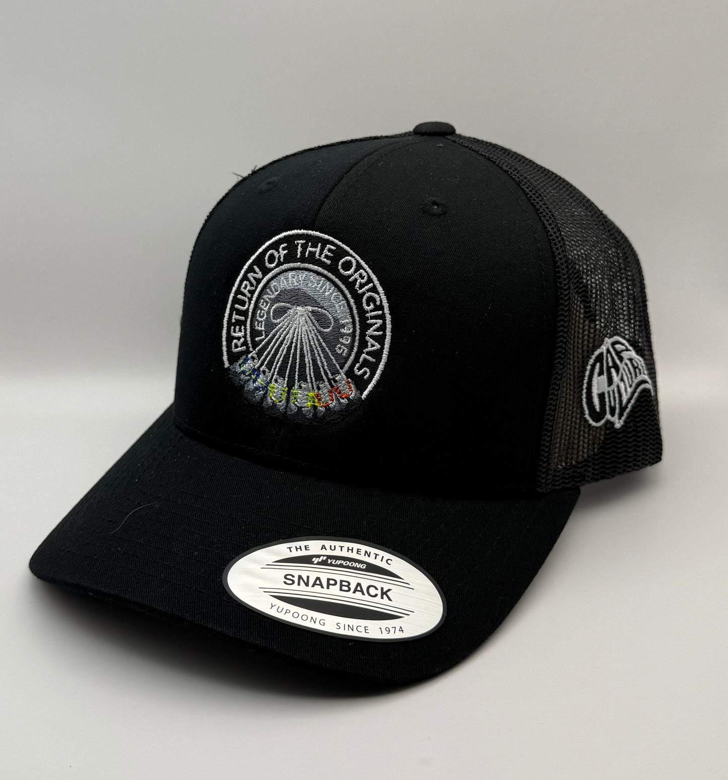 Black cap with embroidered designs on a light gray background