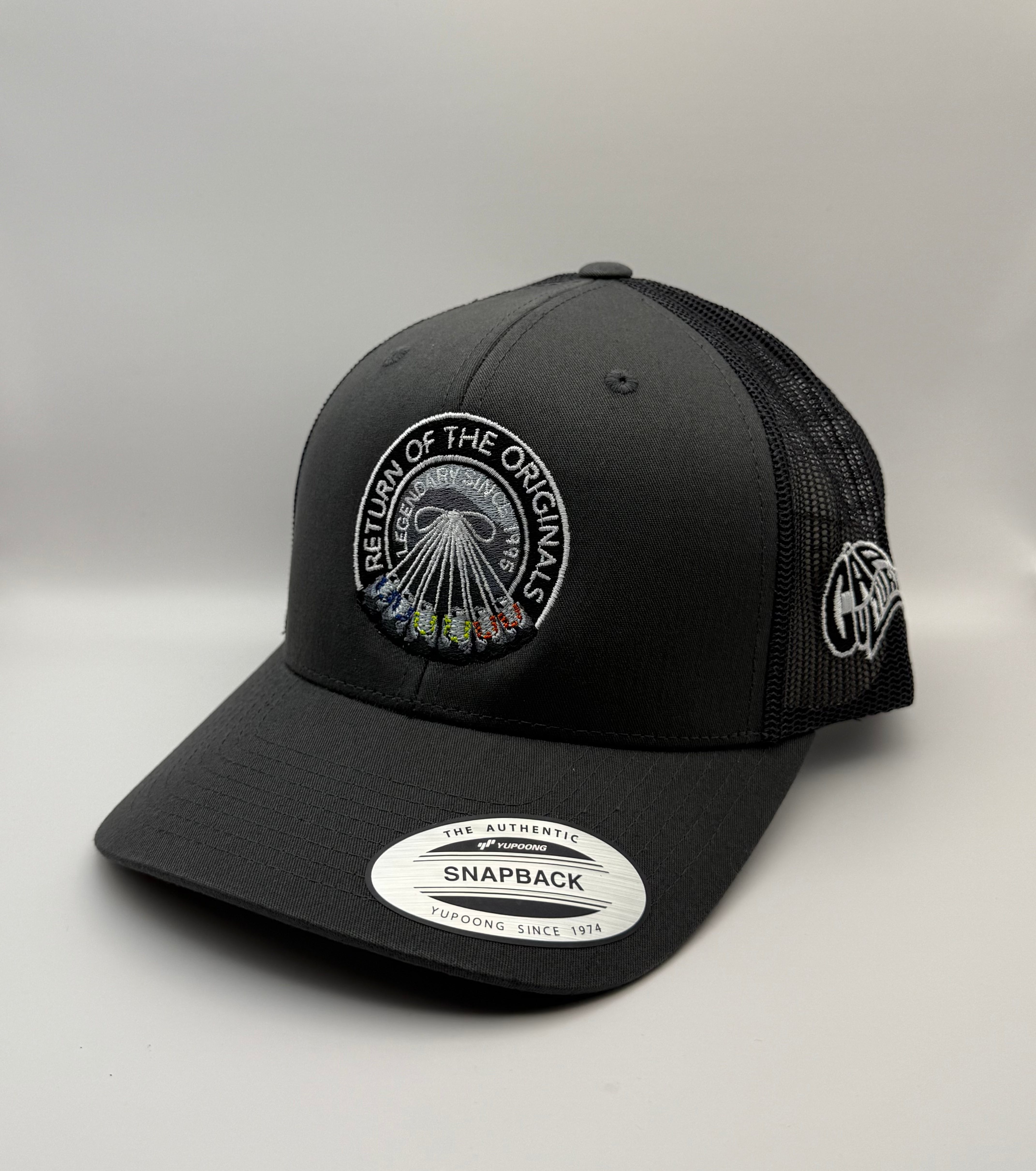 Black trucker cap with embroidered logo on a gray background