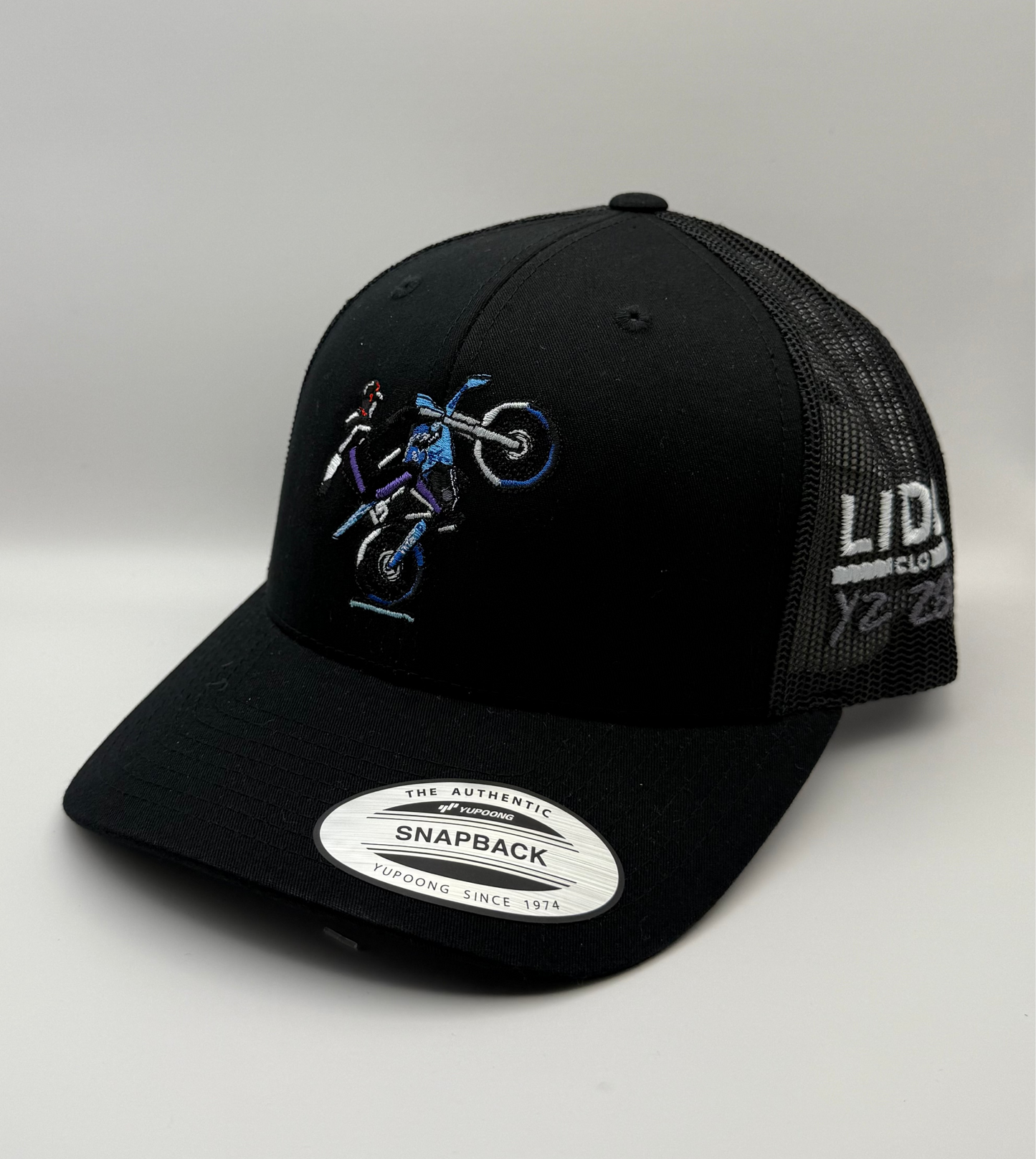 Black cap with blue graphics and 'Lidz' branding on a light grey background. Bike YZ 280
