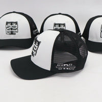 Four black and white caps with logos on a light gray background