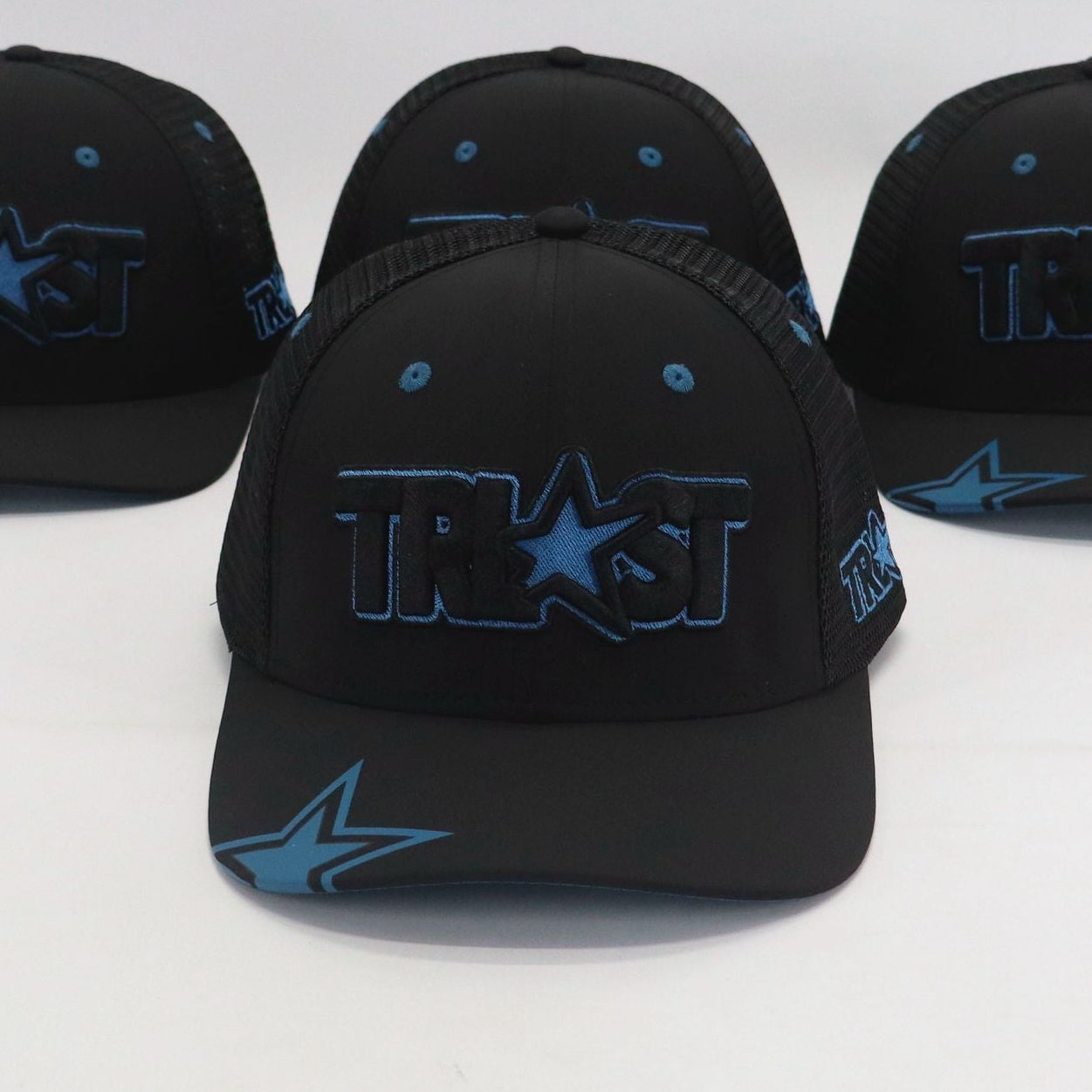Four black caps with blue logos on a white background