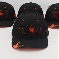 Four black baseball caps with orange logos on a white background