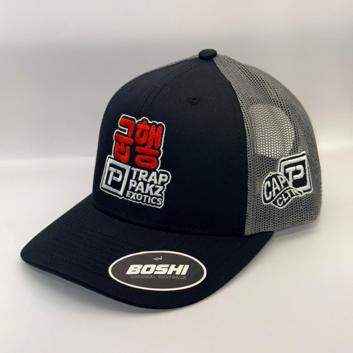 Black and gray cap with multiple brand logos on a white background