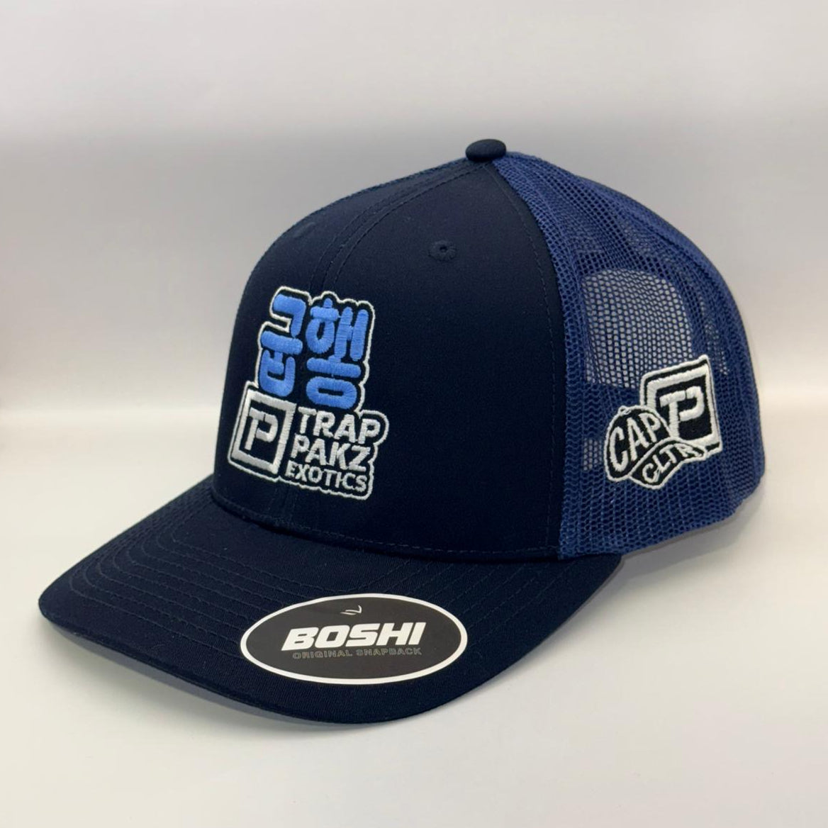 Navy blue cap with multiple brand logos on a white background