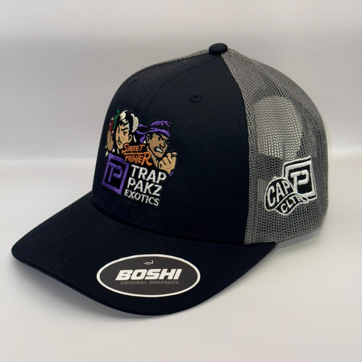 Black and gray cap with multiple brand logos on a white background