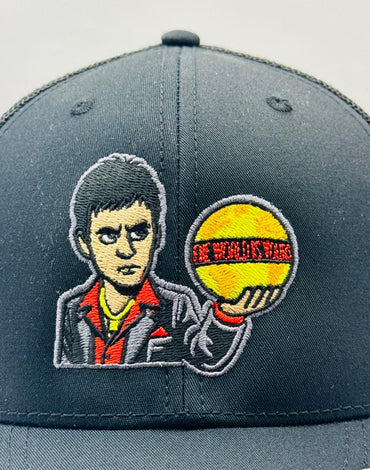 Gray cap with embroidered design of a character holding a ball on a gray background