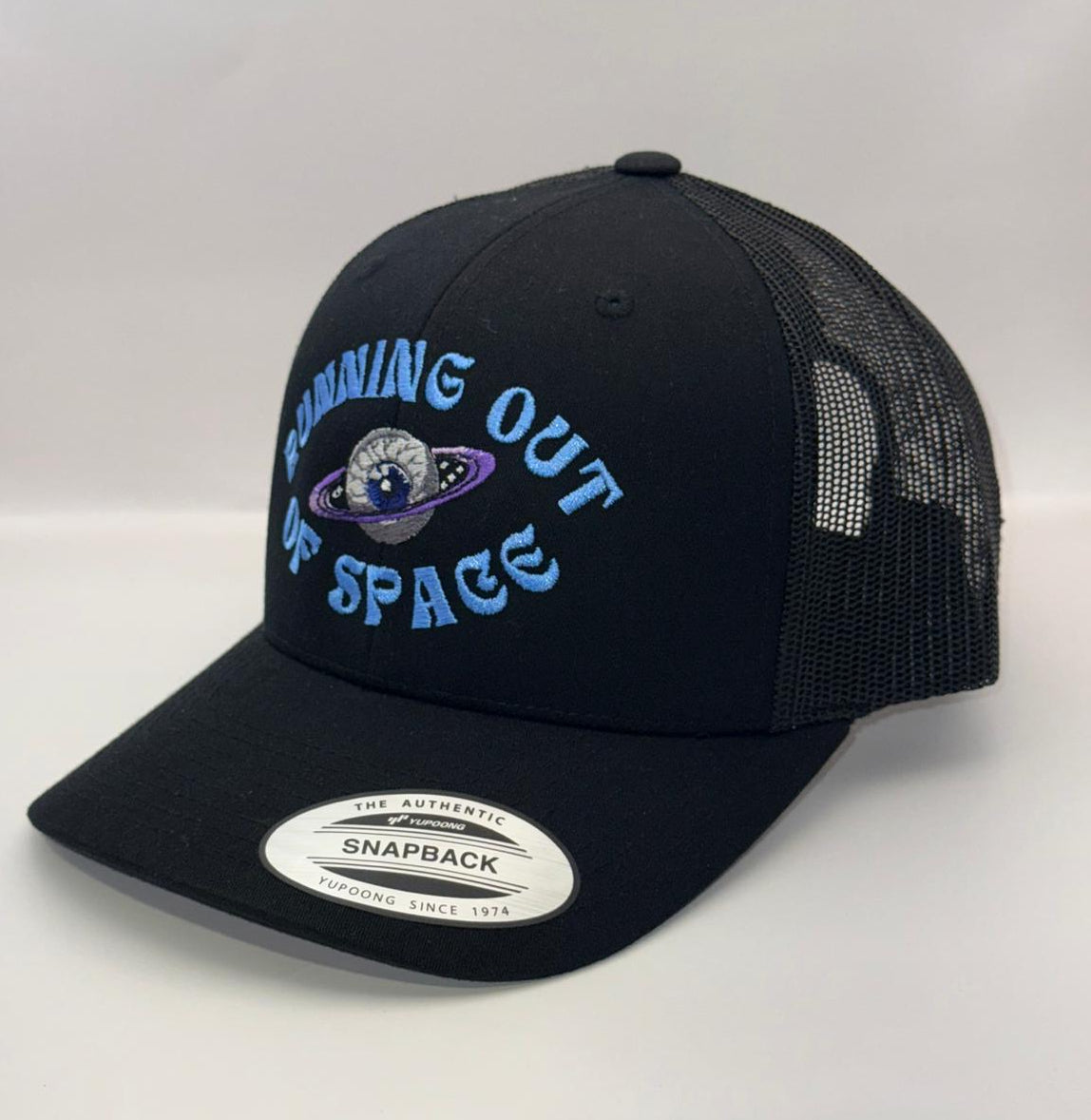 Black trucker cap with 'Dreaming Out of Space' logo on a white background