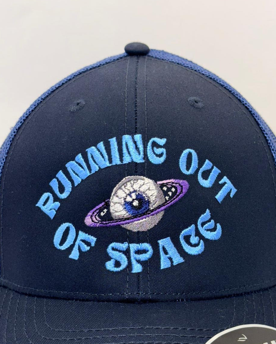 Navy blue cap with 'Running Out of Space' text and planet graphic on a white background