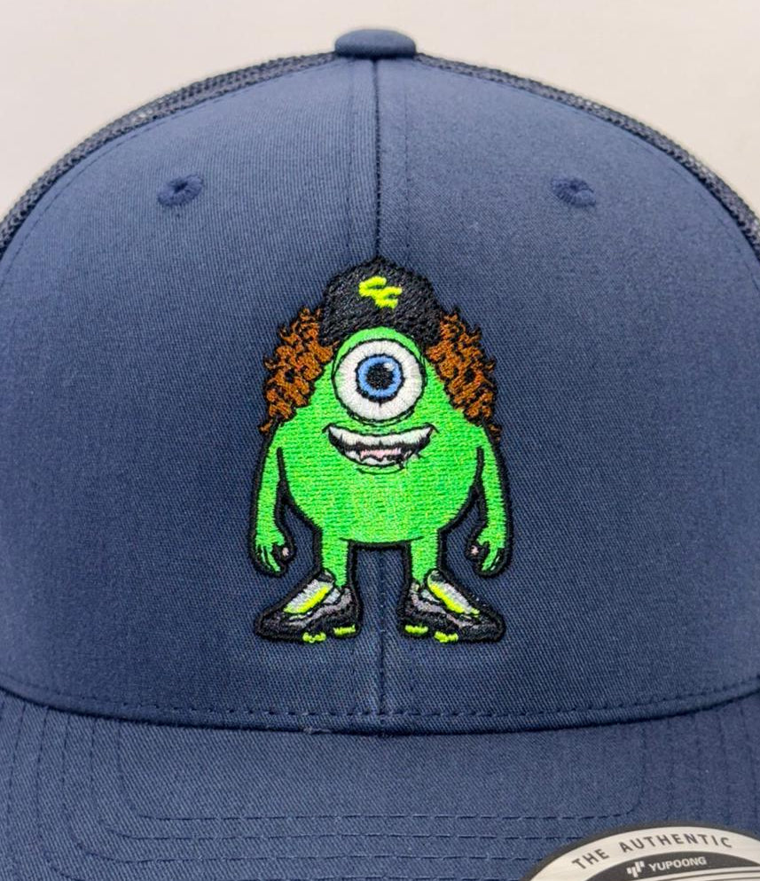 Blue snapback cap with a green character design on a white background