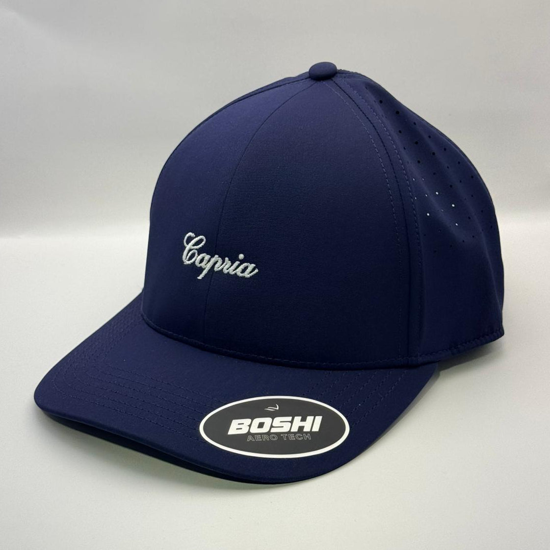 Navy blue cap with 'Capria' branding on a white background