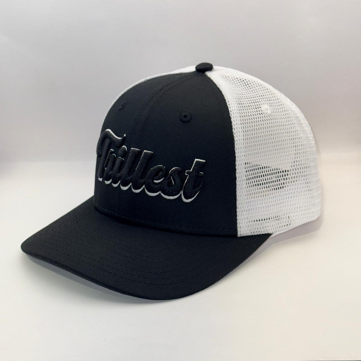 A black and white trucker cap with a black front panel and brim, white mesh back panels, and a black embroidered script logo on the front.