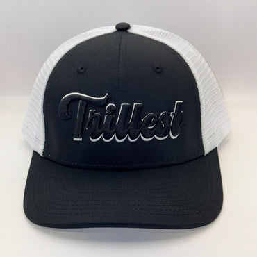 A black and white trucker hat with a black front panel, white mesh back, and a black embroidered 'Trilkest' logo on the front.