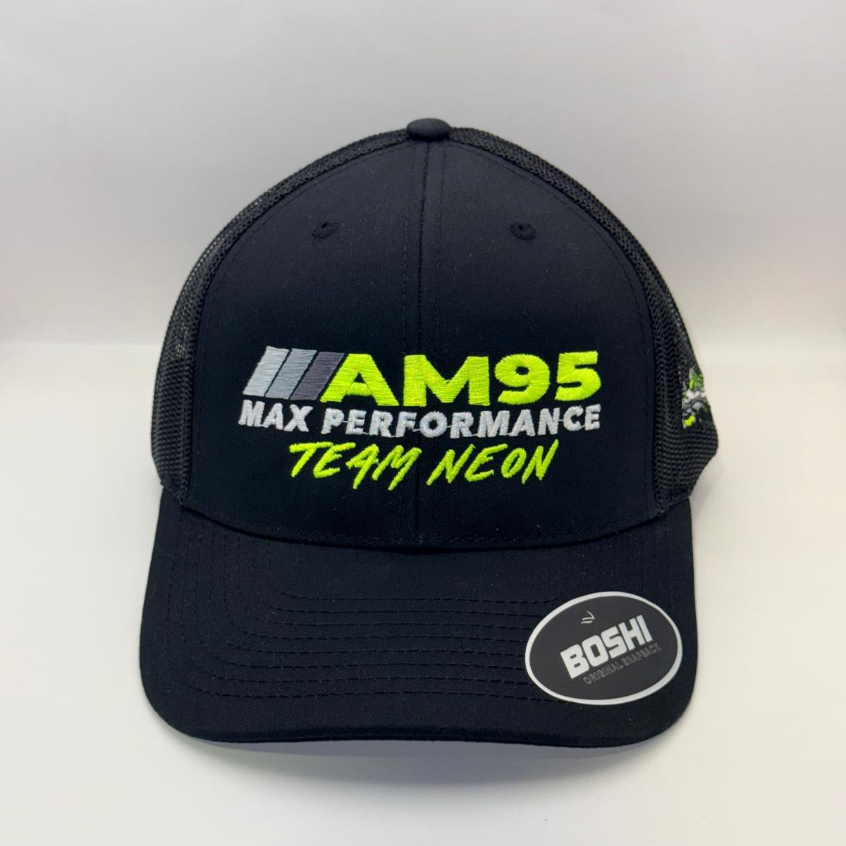 A black trucker-style cap with mesh back panels, featuring 'AM95 MAX PERFORMANCE TEAM NEON' embroidered on the front in neon green and white, with a circular 'BOSHI' sticker on the brim.