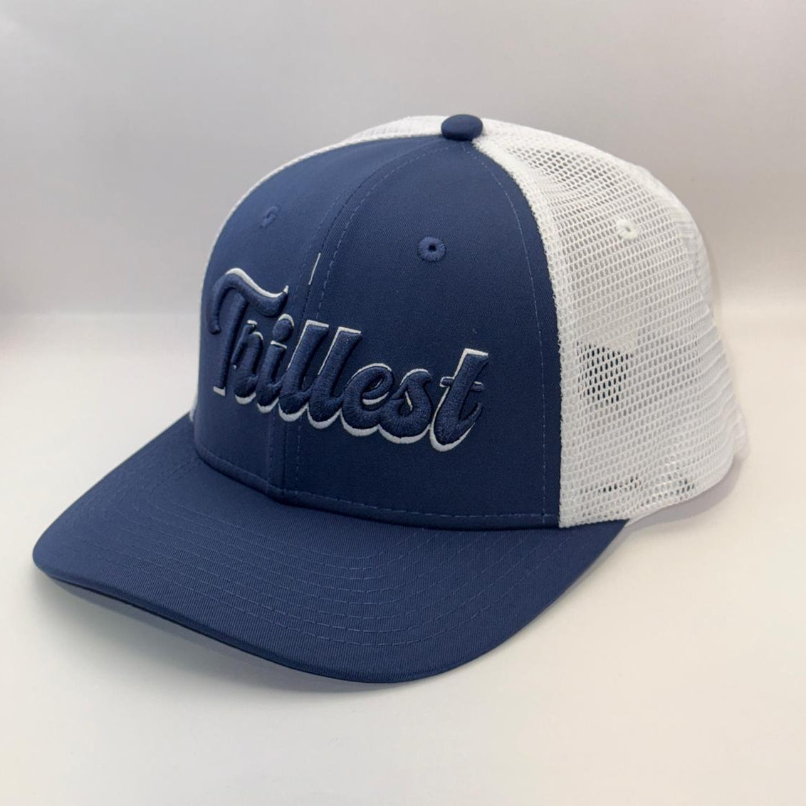 A navy blue and white trucker hat with 'Tallest' embroidered in white script on the front panel, set against a plain light background.
