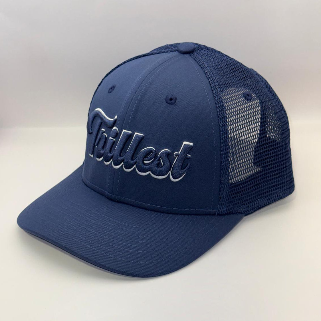A navy blue trucker hat with a curved brim, featuring the word 'Tallest' embroidered in white script across the front panels and a matching navy mesh back.
