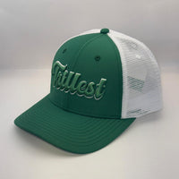 A green and white trucker-style baseball cap with 'Tittest' embroidered in white script across the front panels, set against a plain light gray background.