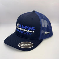 A navy blue and royal blue trucker hat with 'AM95 MAX PERFORMANCE TEAM BLUE SPARK' embroidered on the front and a 'BOSHI' sticker on the brim, set against a plain light gray background.
