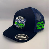 A navy blue trucker hat with a flat brim and mesh back, featuring a 'Capri Farms' logo on the front and neon green text on the side, with a 'BOSHI' sticker on the brim.