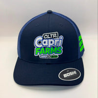A navy blue trucker hat with a large embroidered front patch reading 'CLTR Capri Farms' in white, blue, and green. The cap has navy blue mesh side panels, a matching navy brim, and a visible 'BOSHI' sticker on the brim.