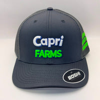 A dark gray mesh-back baseball cap with 'Capri FARMS' embroidered on the front in white and bright green, featuring a visible BOSH brand sticker on the brim.