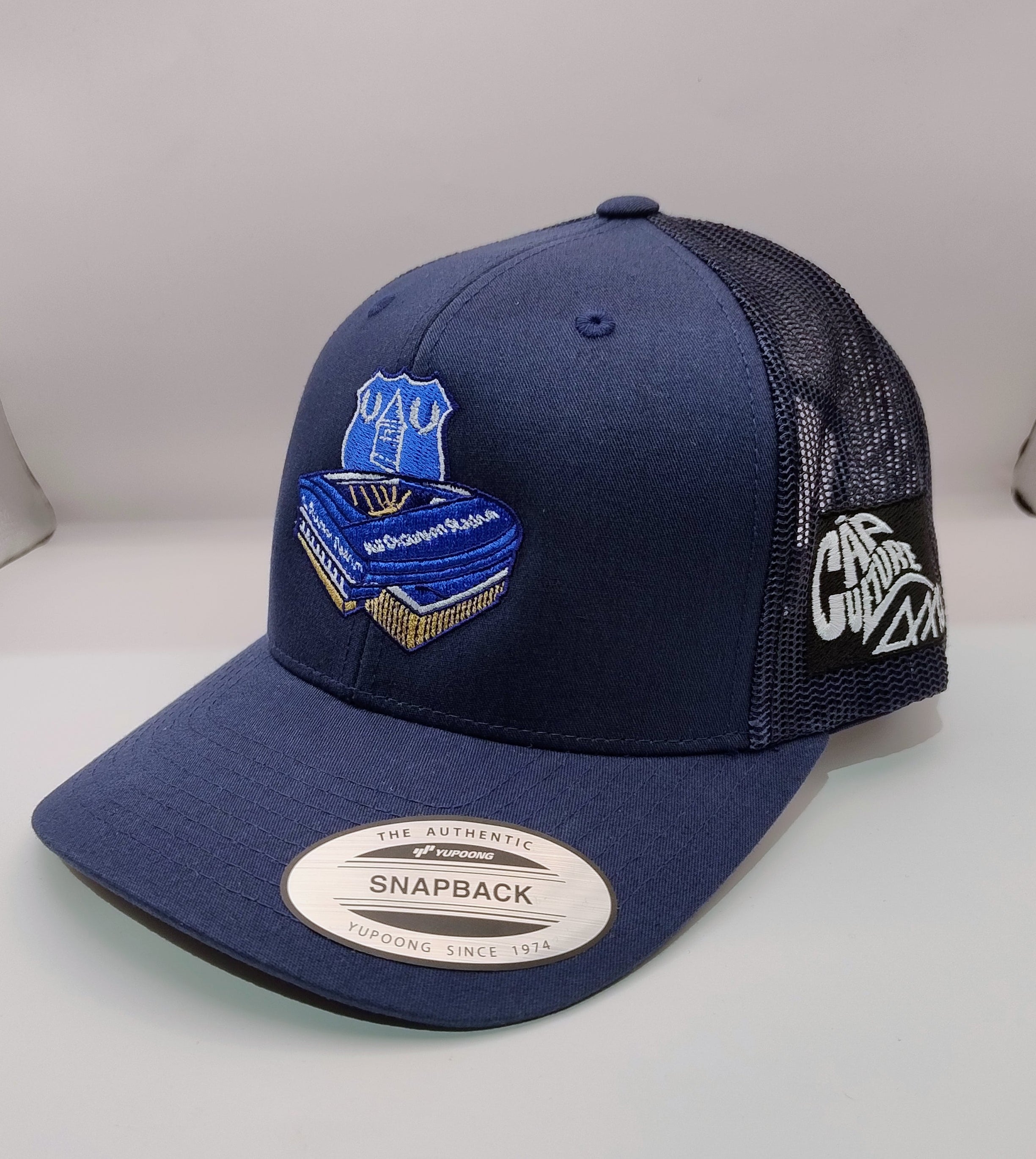 Navy blue cap with embroidered design on a light gray surface