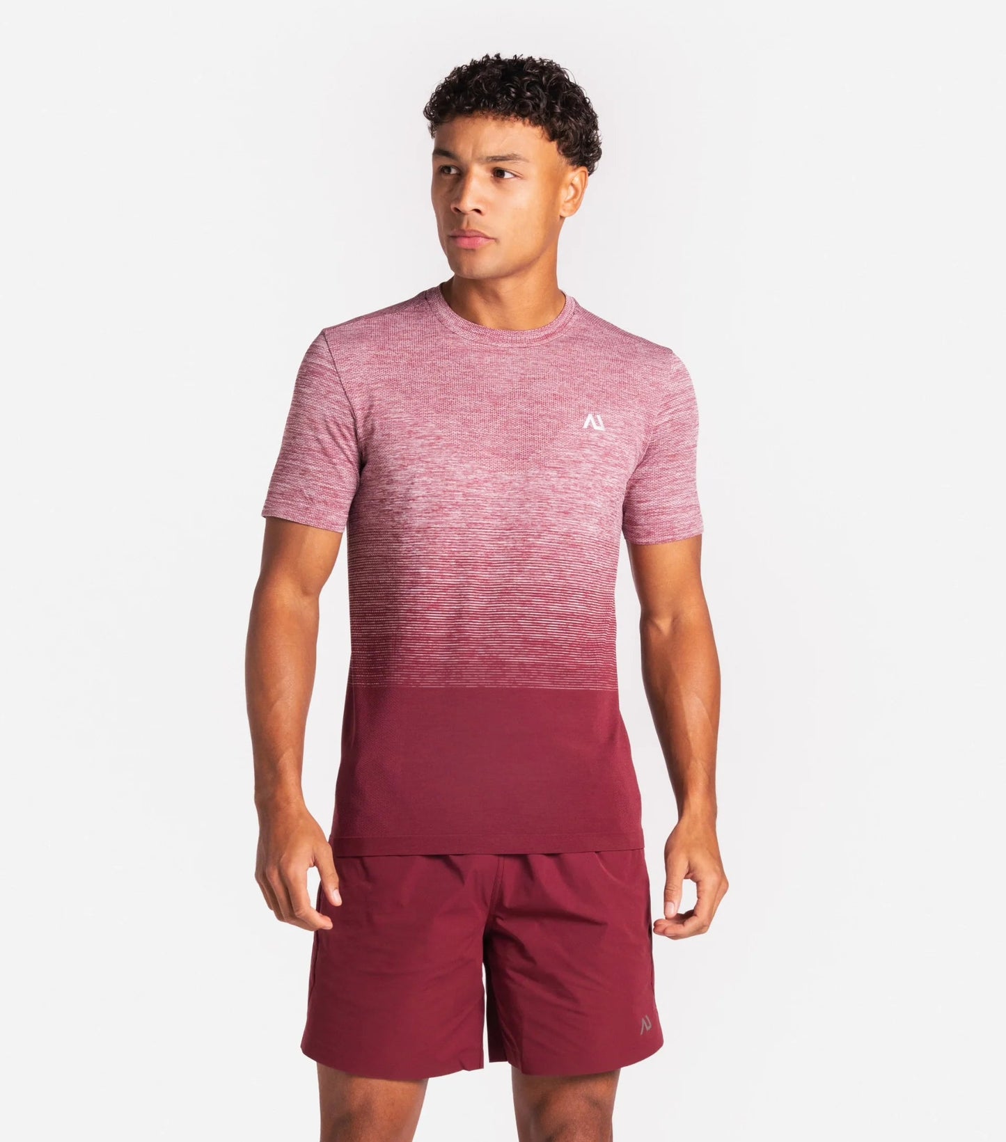 Person wearing a maroon and pink gradient outfit on a white background